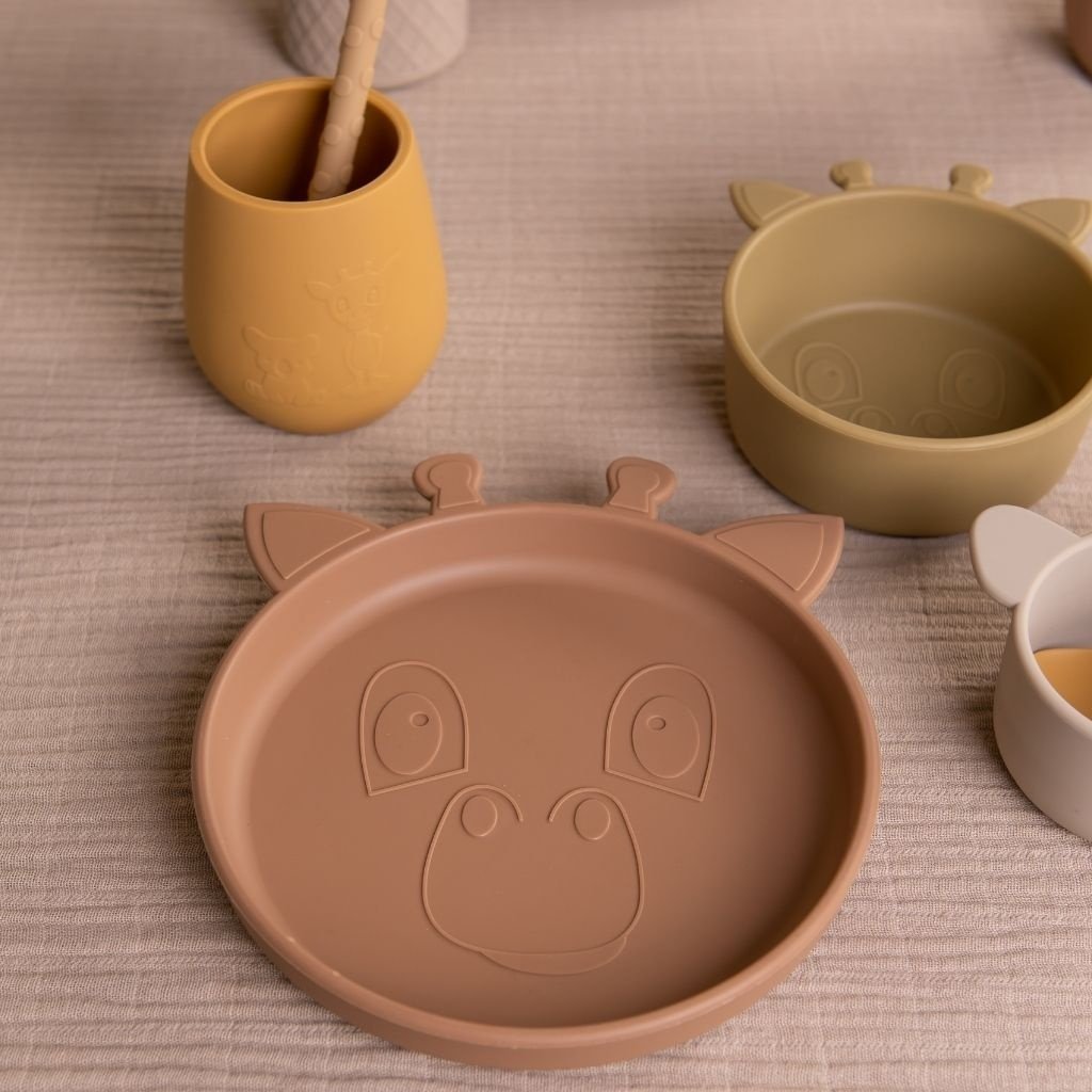 Baby eet zelfstandig met de bruine Nuuroo siliconen eetset aan tafel