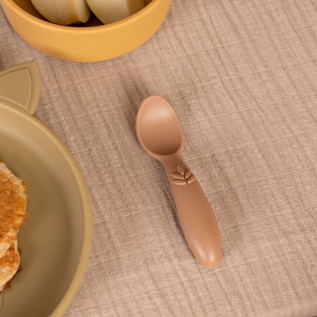  Baby eet zelfstandig met de bruine Nuuroo siliconen eetset aan tafel - anti-slip