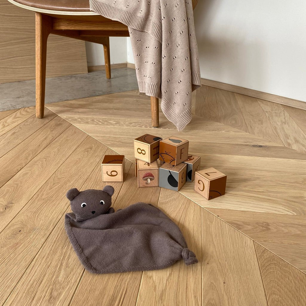 Baby knuffelt met biologisch gebreide beer van Nuuroo