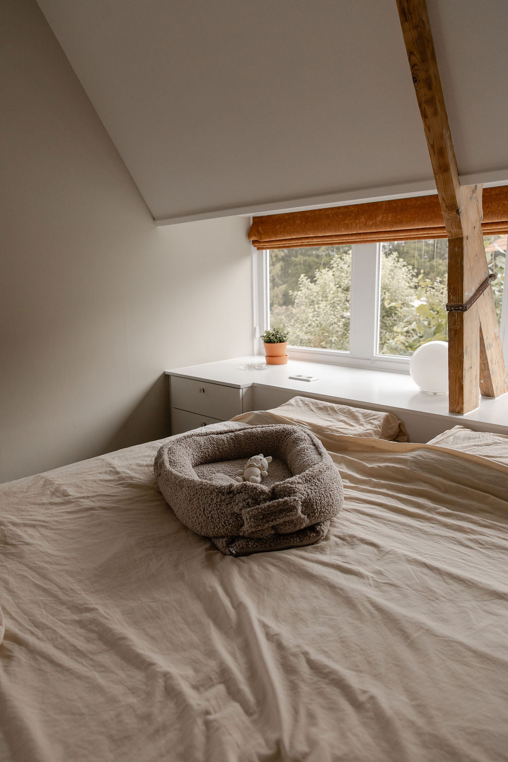 Een overzicht van het lege Benni & Ninni Teddy Babynest Tan op een bed.