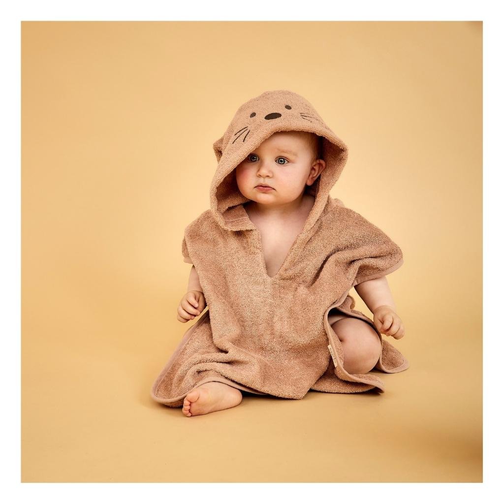 Jonge kind draagt roze biologische badstofponcho met konijnenoren na het bad

