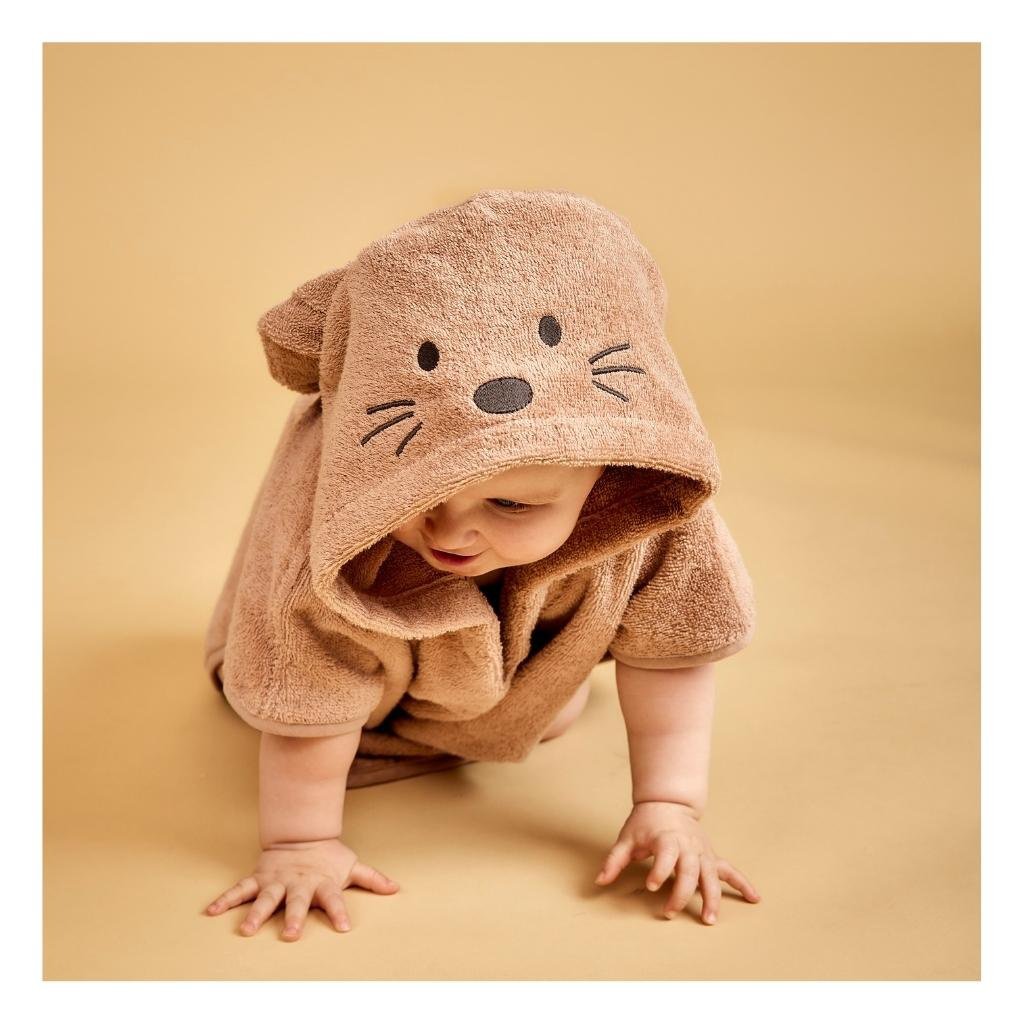 onge kind draagt roze biologische badstofponcho met konijnenoren na het bad

