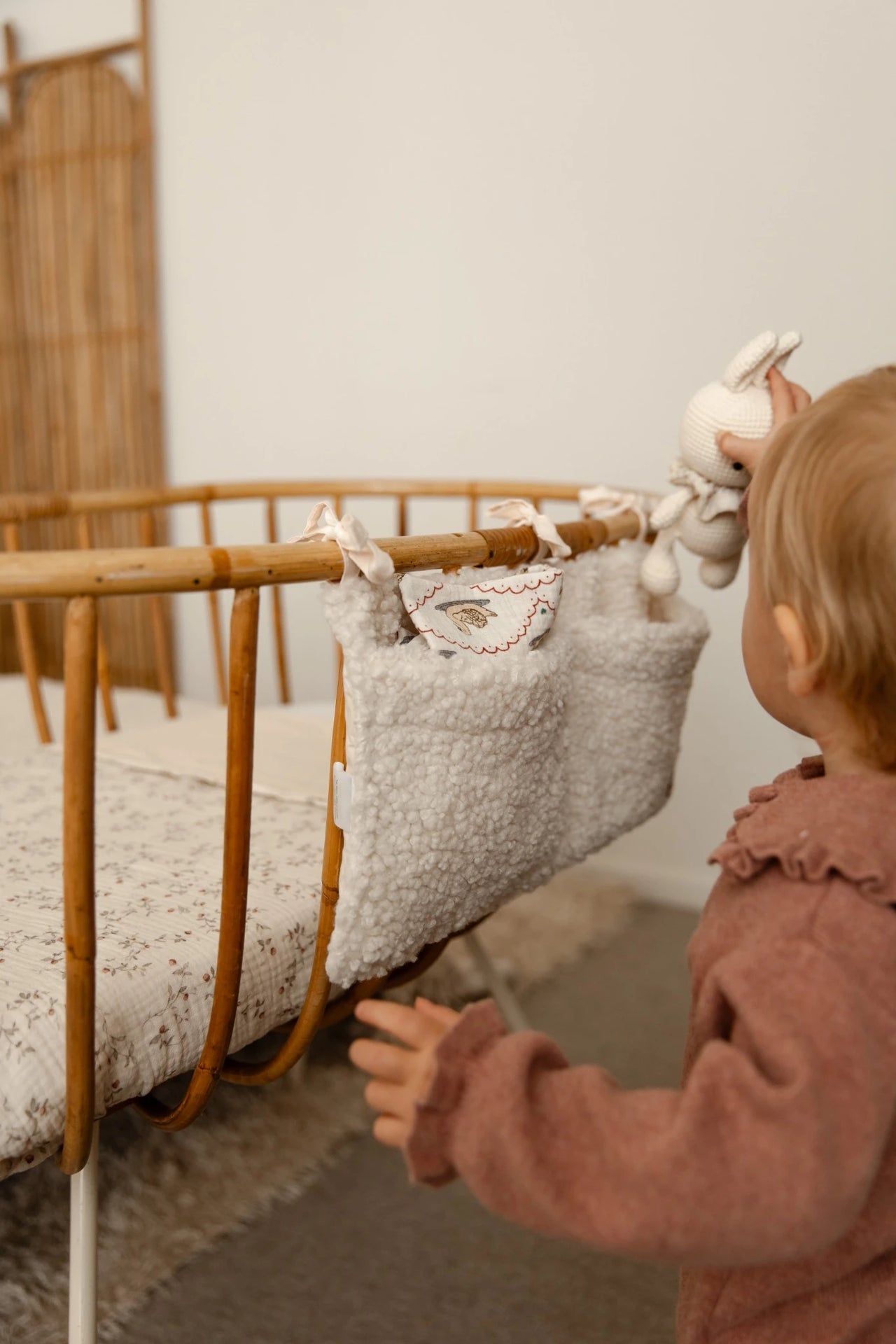 Peuter pakt speelgoed uit teddy cream crib organizer
