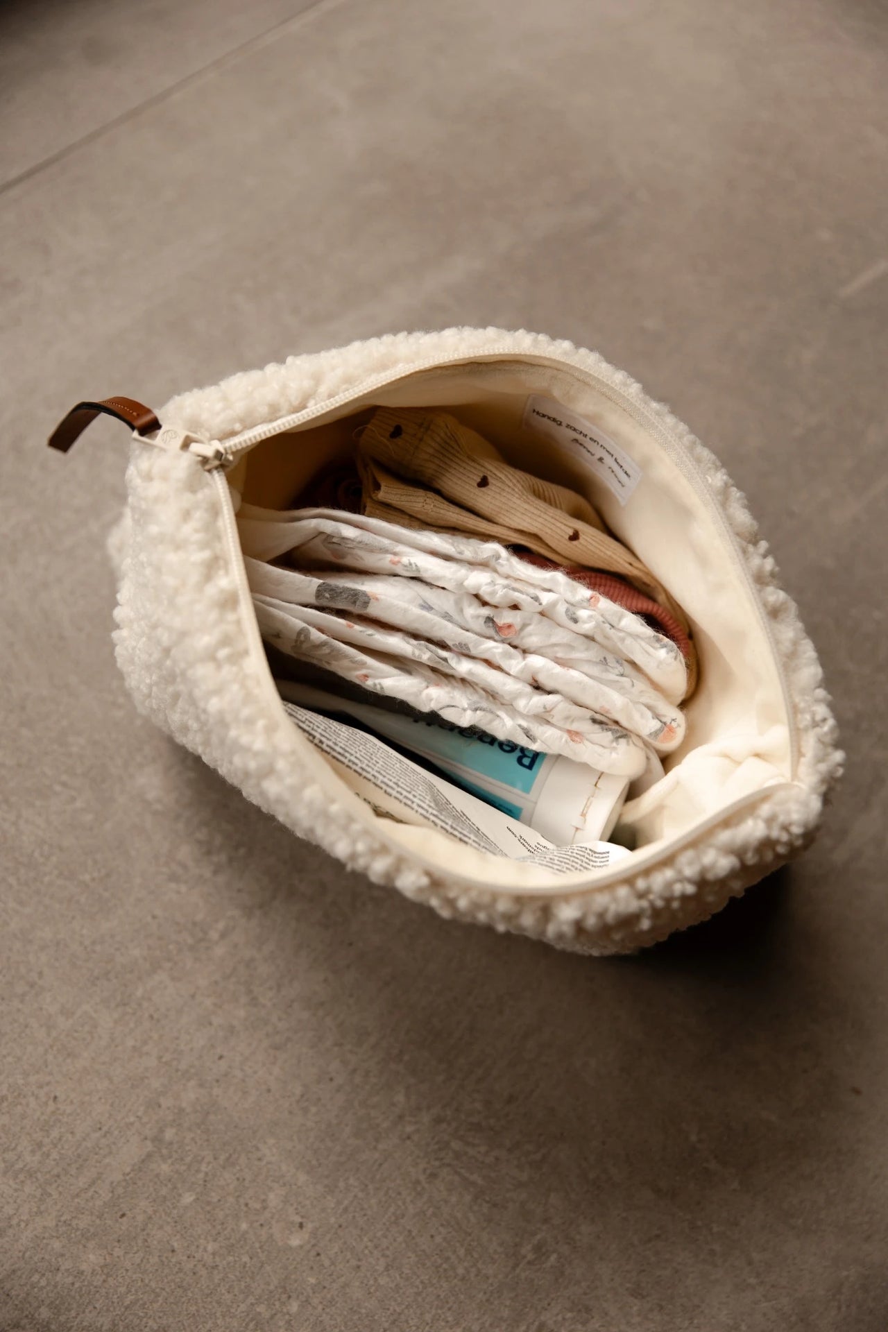 Luieretui Teddy Cream open met luiers en verzorgingsproducten