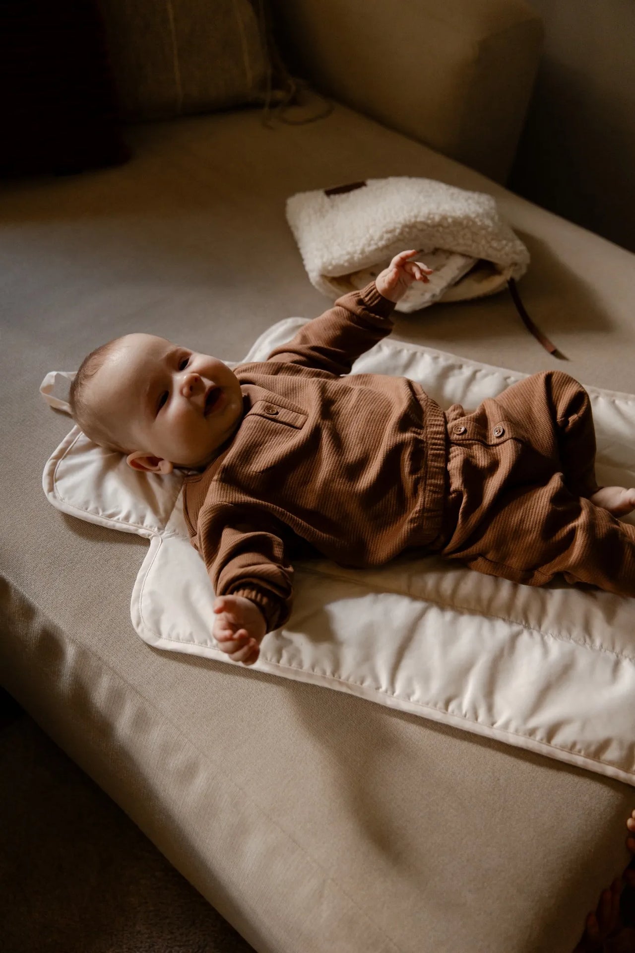 Baby liggend op de zachte verschoonmat uit de Benni & Ninni On-the-Go set.