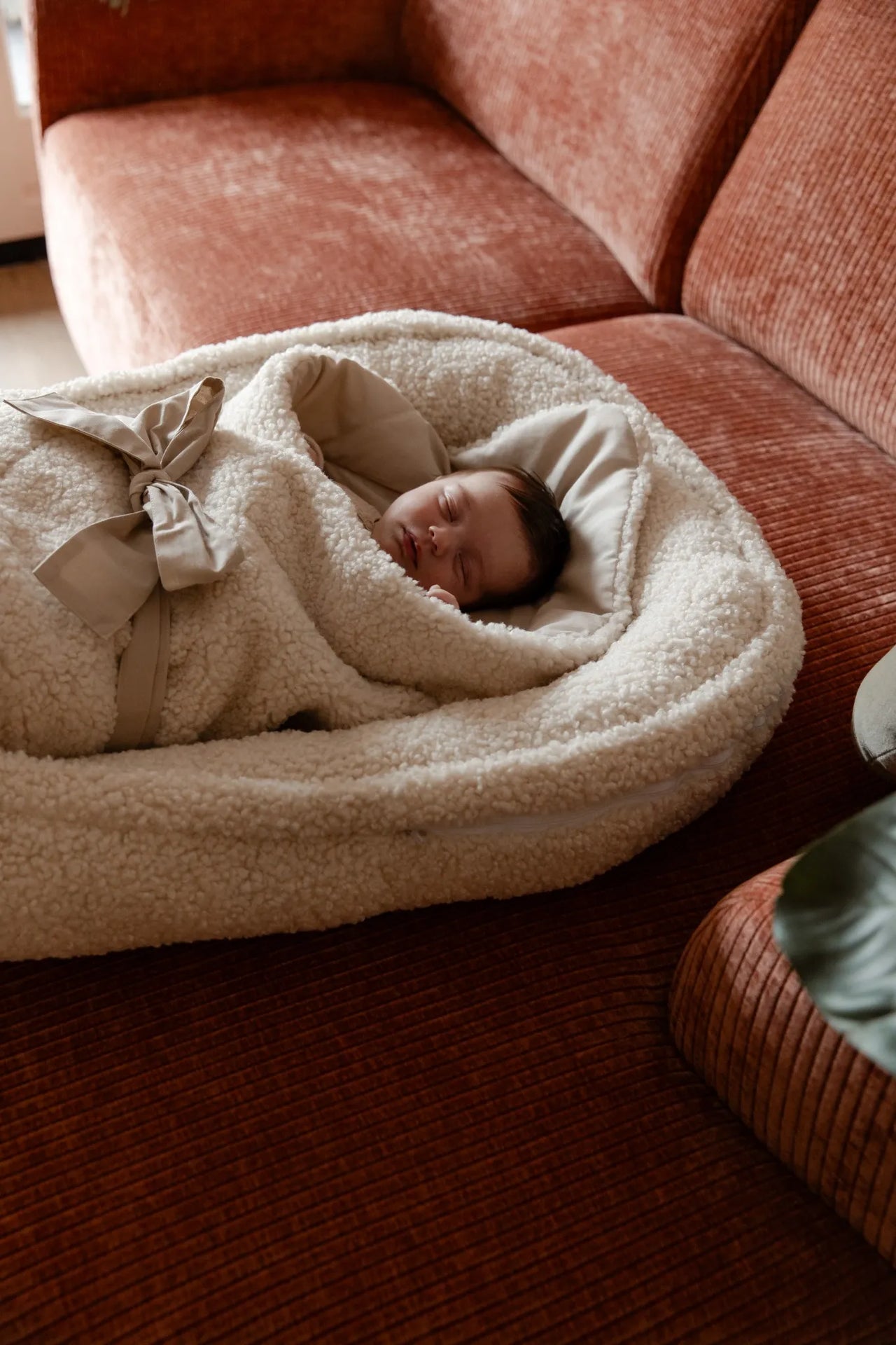 Baby slapend in zacht teddy babynest voor ultiem slaapcomfort.