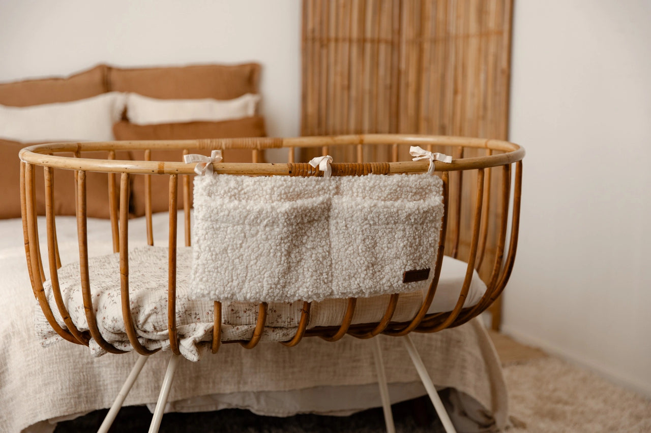 Teddy crib organizer cream bevestigd aan een rotan wieg