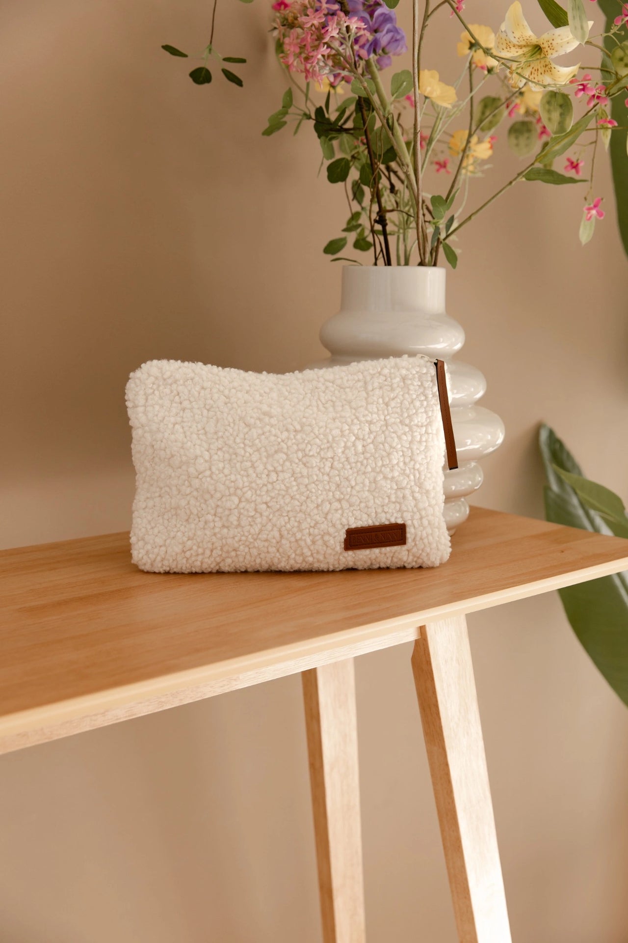 Teddy luieretui in cream op houten tafel met bloemenvaas