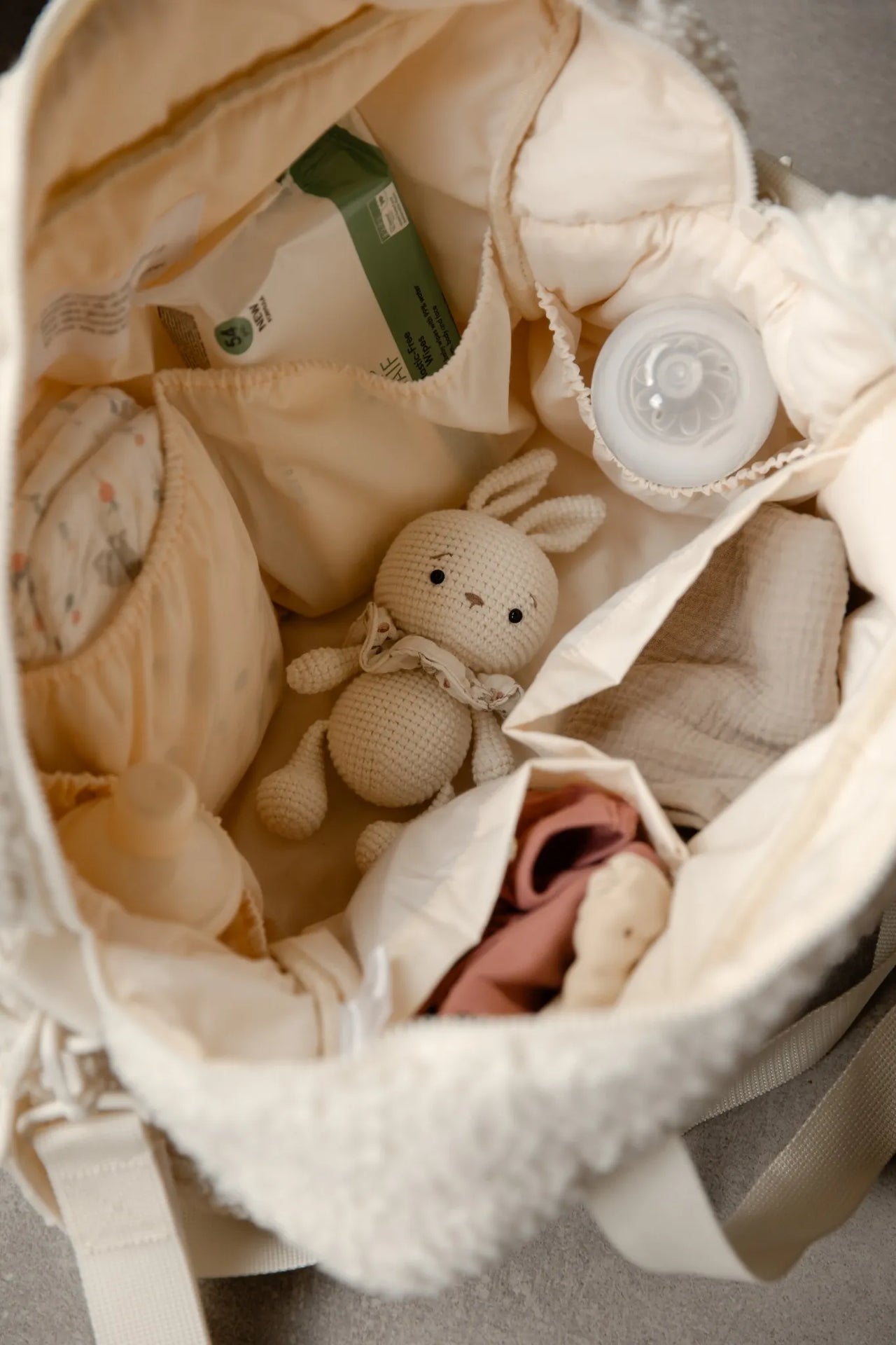 Binnenkant van teddy luiertas cream gevuld met babyspullen