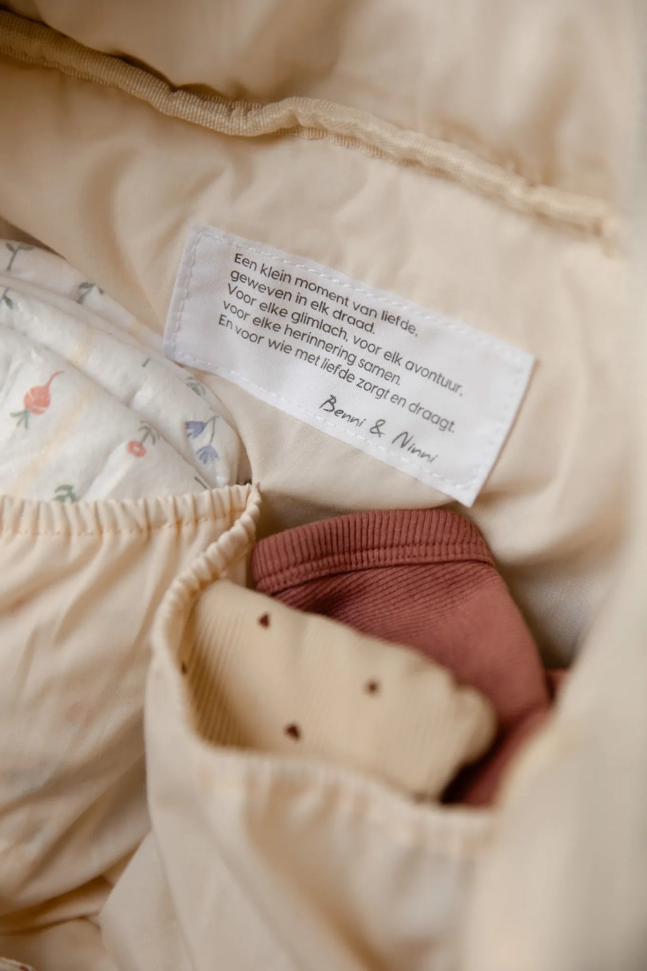 Detail van Benni & Ninni label in teddy luiertas cream